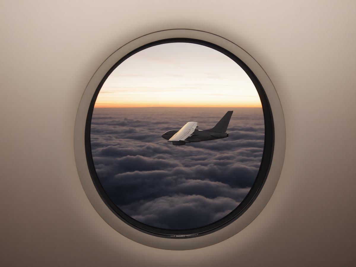 Vue d'une aile au-dessus des nuages depuis le hublot d'une cabine privée